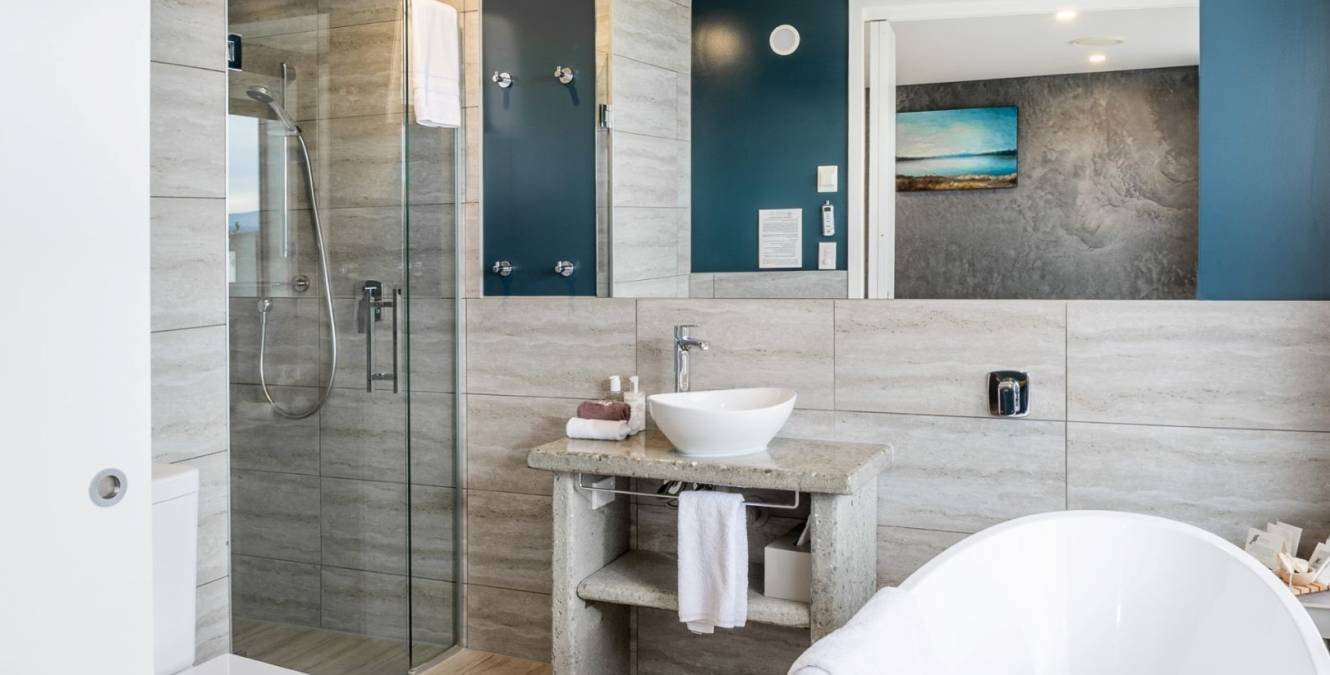 Modern ensuite bathroom in the Lake View Super King Room featuring a walk-in rain shower, freestanding bath and luxury amenities.
