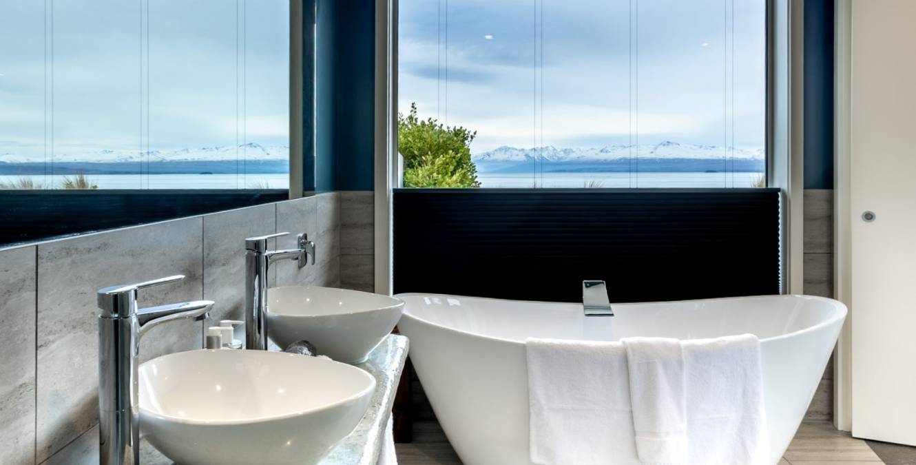 Freestanding bath in the Lake View Spa Suite overlooking Lake Pūkaki and the Southern Alps with double vanity bathroom