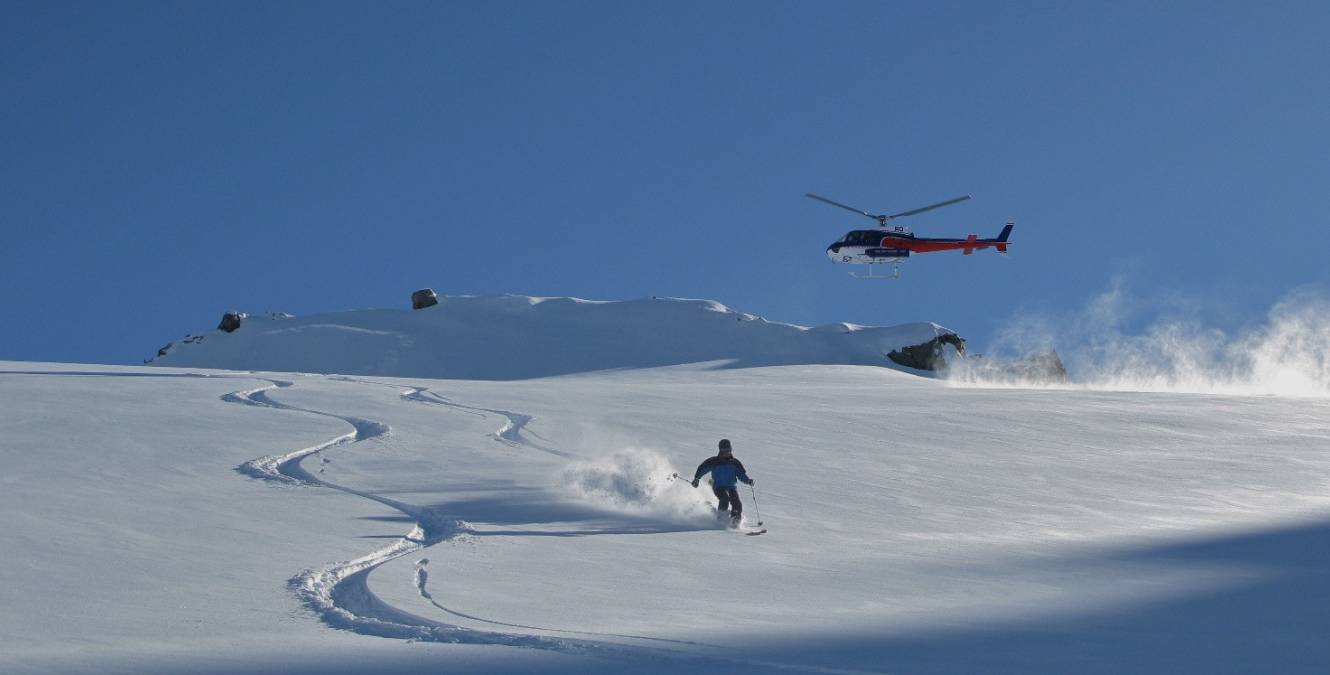 Skiers enjoying the fresh powder on the slopes at Ohau Ski Field, with panoramic mountain views